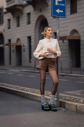 a lady in a brown eco-friendly leather a-line shorts with a white jacket